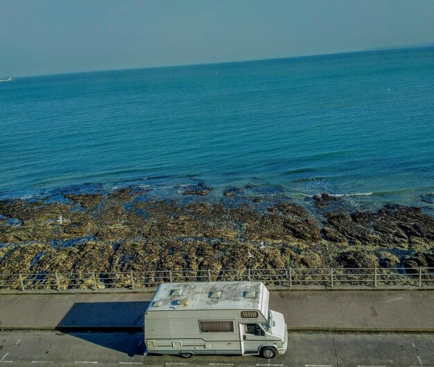 Foto vista panoramica del mare con furgone sulla strada contro un cielo limpido