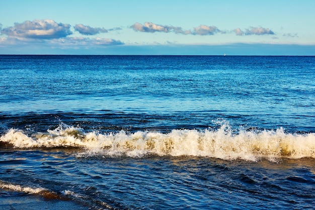 Scenic view of sea with waving crashing against sky