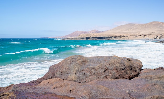 Photo scenic view of sealandscape with a wave coming up to the coast in fuerteventuracanary island