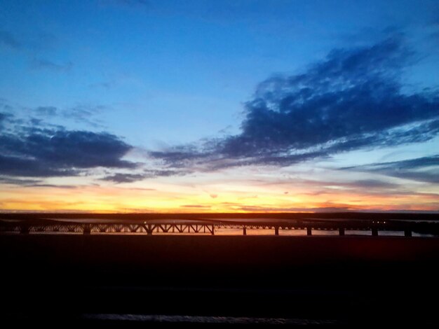 Scenic view of silhouette beach against sky during sunset