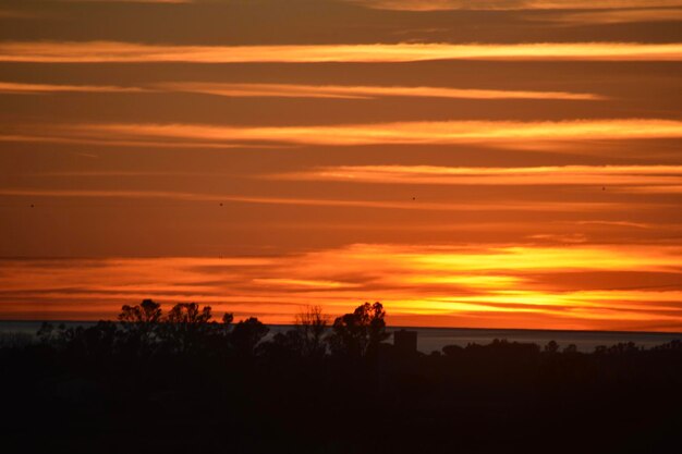 Scenic view of silhouette landscape against orange sky