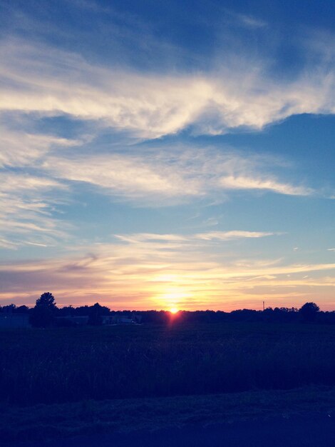 Photo scenic view of silhouette landscape against sky during sunset