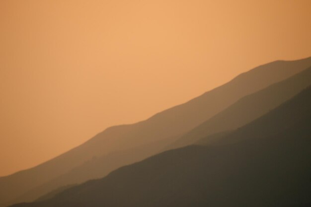 Foto vista panoramica della montagna a silhouette contro il cielo arancione