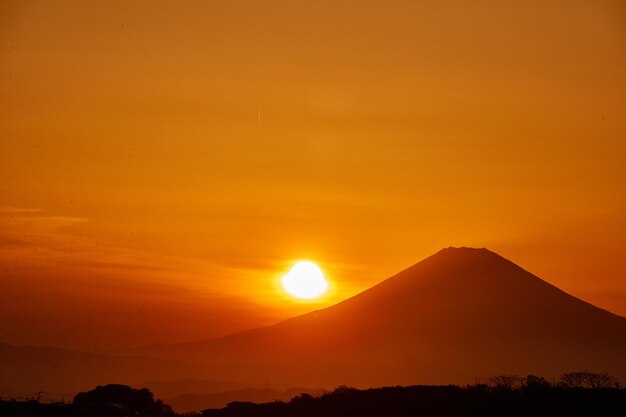 Scenic view of silhouette mountain against orange sky