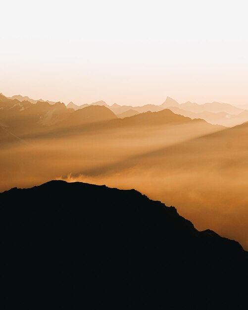 Photo scenic view of silhouette mountain against sky during sunset