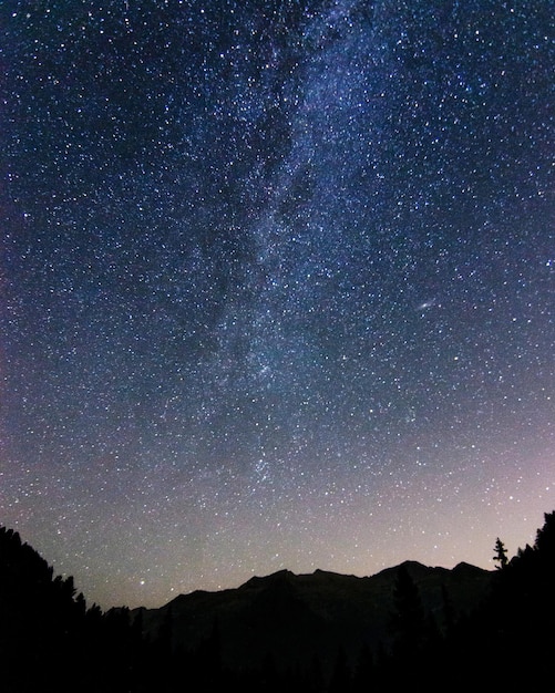 Scenic view of silhouette mountain against star field at night - location cervinia - italy