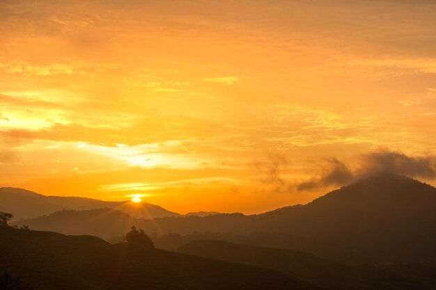 Scenic view of silhouette mountains against orange sky