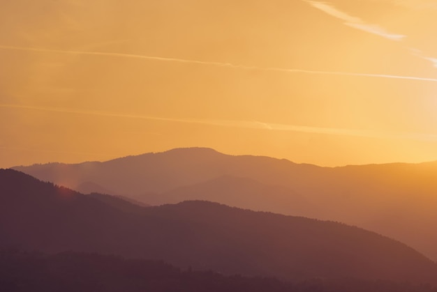 Scenic view of silhouette mountains against orange sky