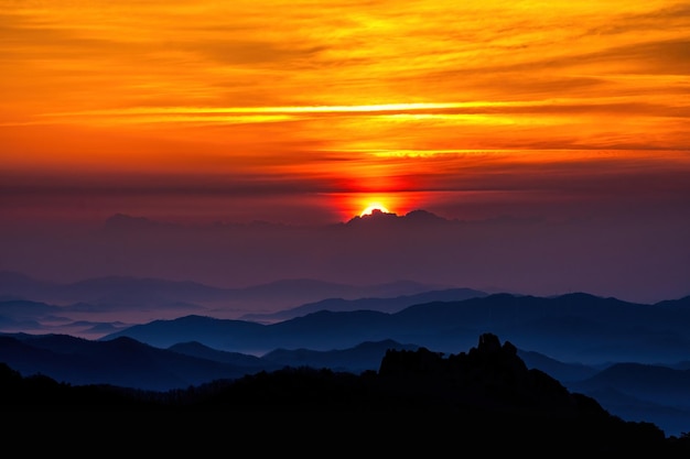 オレンジ色の空の背景にある山のシルエットの景色