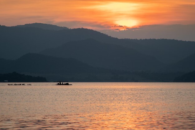 Foto la vista panoramica delle montagne a silhouette contro il cielo arancione