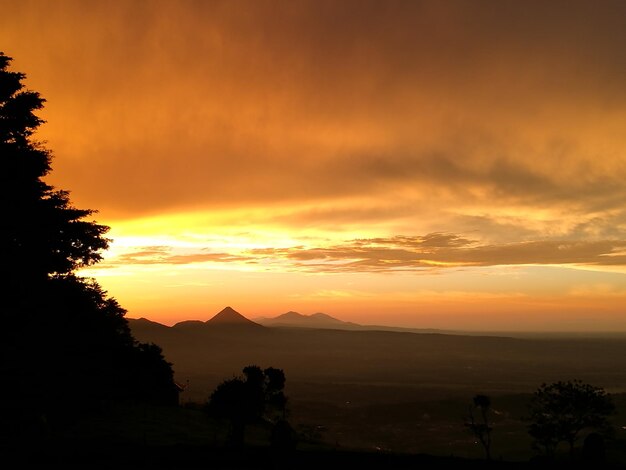 Scenic view of silhouette mountains against orange sky