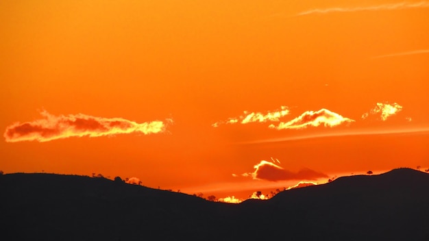 Scenic view of silhouette mountains against orange sky