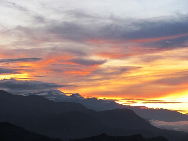 Scenic view of silhouette mountains against orange sky