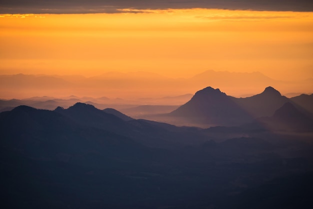 オレンジ色の空の背景にある山のシルエットの景色