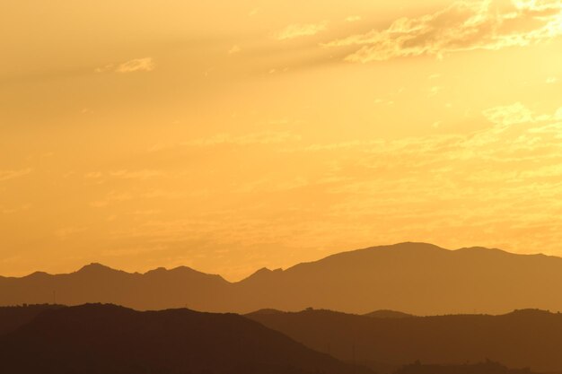 Photo scenic view of silhouette mountains against romantic sky at sunset