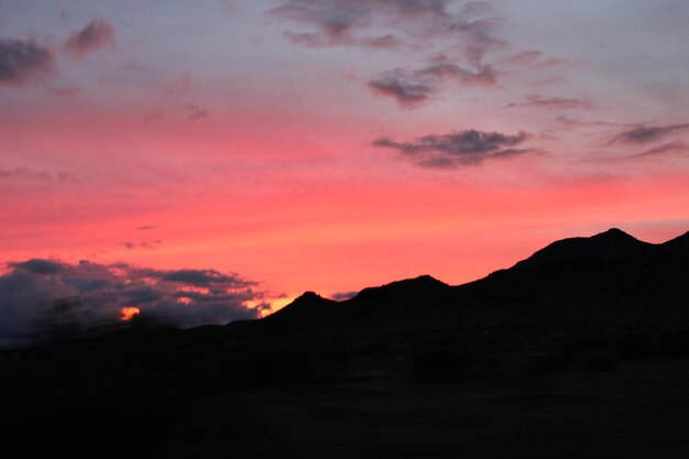 Scenic view of silhouette mountains against romantic sky at sunset