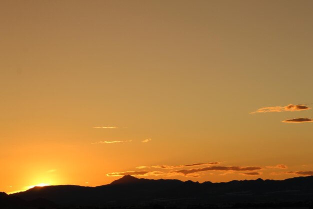 Scenic view of silhouette mountains against romantic sky at sunset