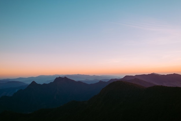 Photo scenic view of silhouette mountains against sky during sunset