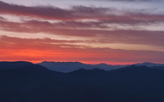 Photo scenic view of silhouette mountains against sky during sunset