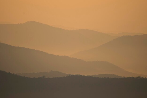 Photo scenic view of silhouette mountains against sky during sunset