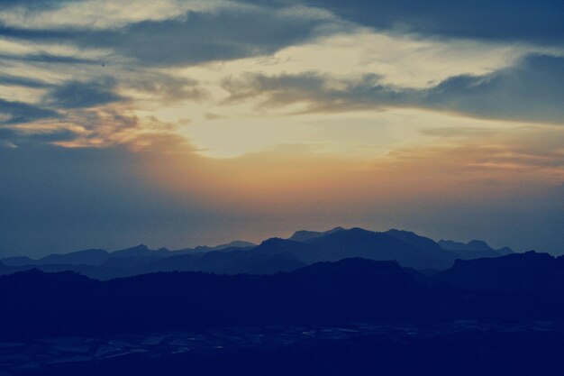 Scenic view of silhouette mountains against sky at sunset