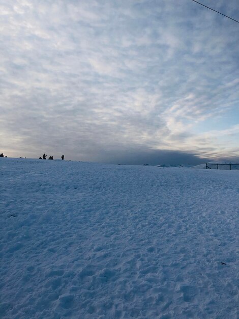 Scenic view of snow covered field against sky