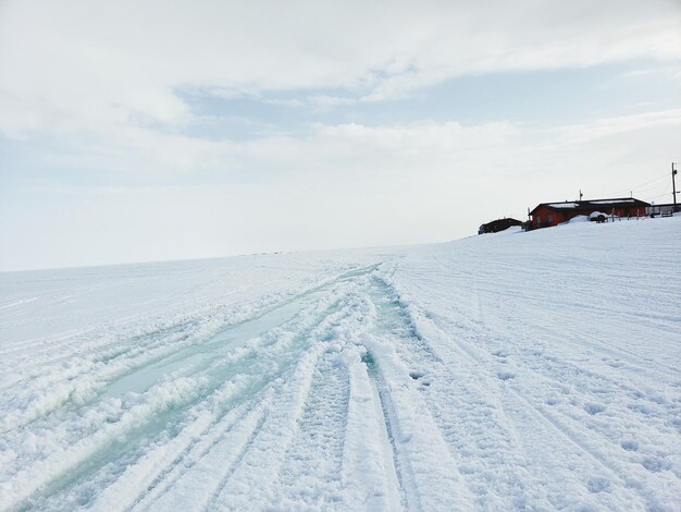 Scenic view of snow covered field against sky