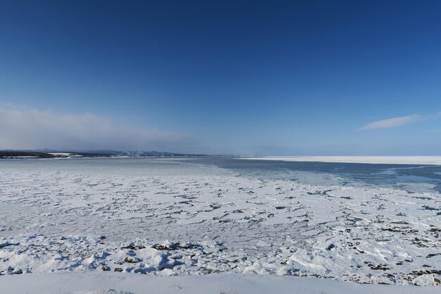 Scenic view of snow covered land against blue sky