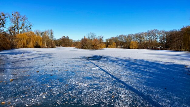 Scenic view of snow covered land against clear blue sky