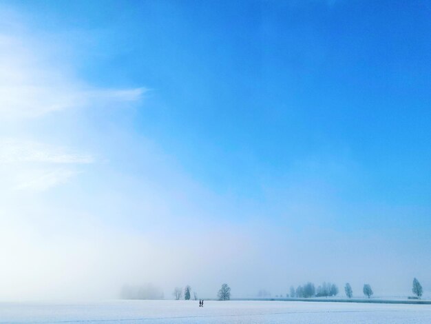 Photo scenic view of snow covered land against sky