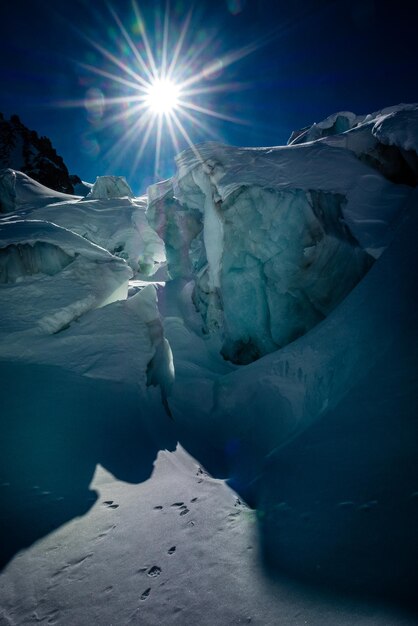 Scenic view of snow covered landscape against bright sun