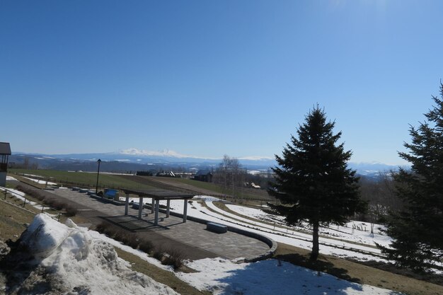 Scenic view of snow covered landscape against clear blue sky