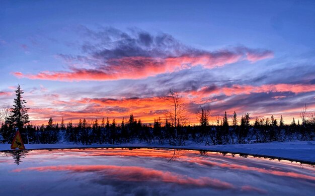 Photo scenic view of snow covered landscape against sky during sunset