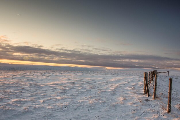 Scenic view of snow covered landscape against sky during sunset