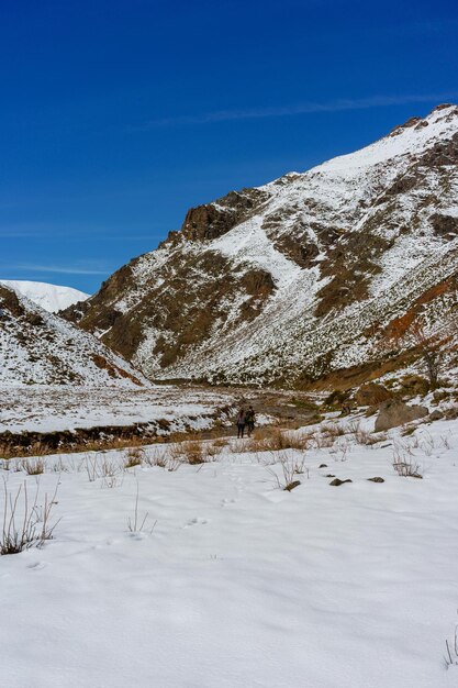 Scenic view of snow covered mountains against blue sky