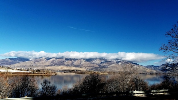 Scenic view of snow covered mountains against blue sky