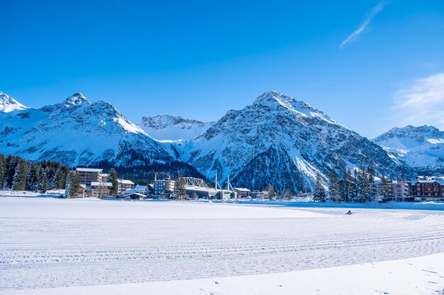 Scenic view of snow covered mountains against blue sky