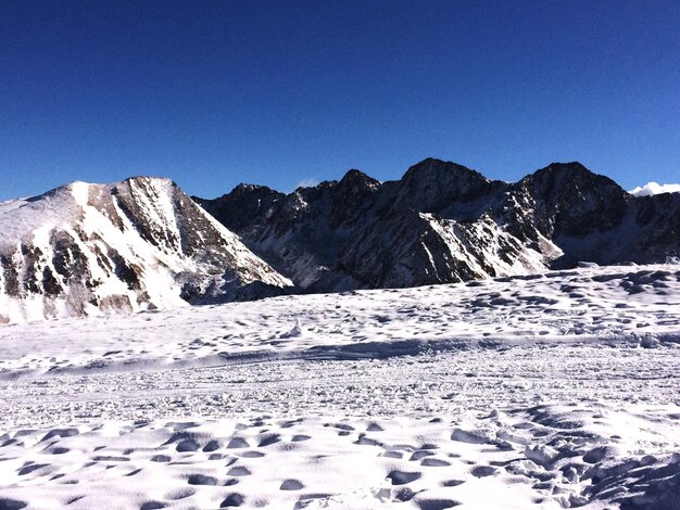 Scenic view of snow covered mountains against clear sky