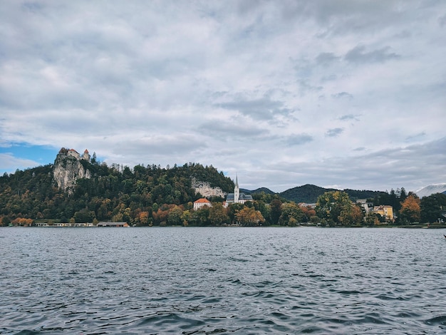 Scenic view of the snow covered mountains peaks against the blue lake Bled, Slovenia. Autumn travel