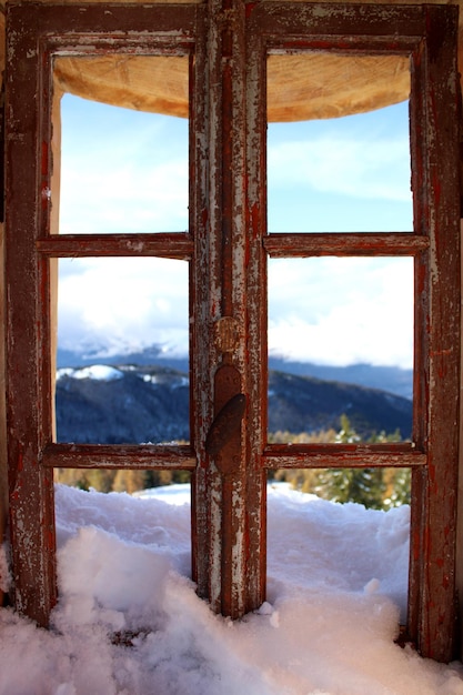 Foto la vista panoramica delle montagne coperte di neve vista dalla finestra