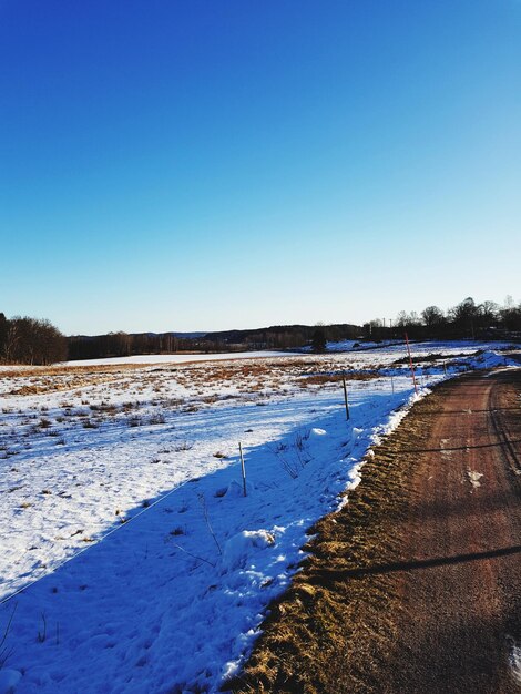 Scenic view of snow field against clear blue sky