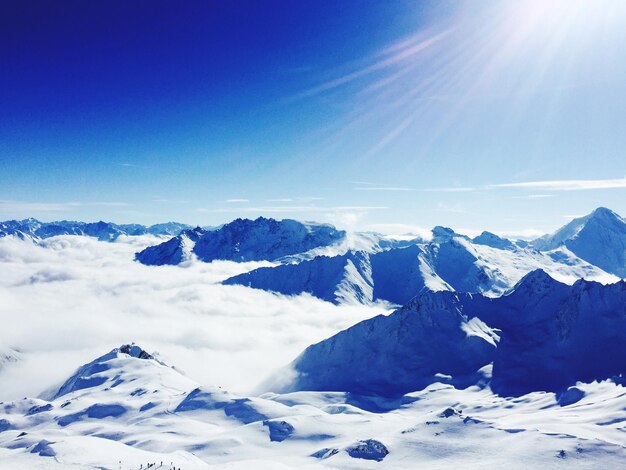 Scenic view of snow mountains against blue sky