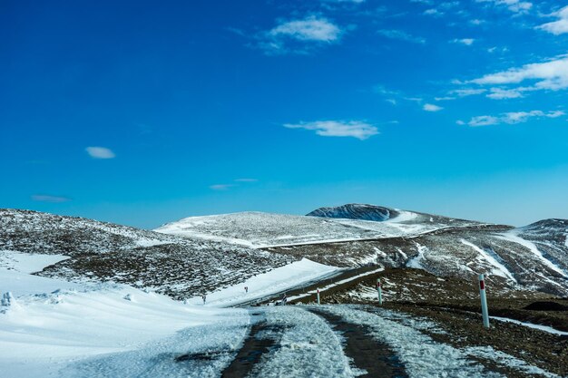 Scenic view of snowcapped mountain against blue sky