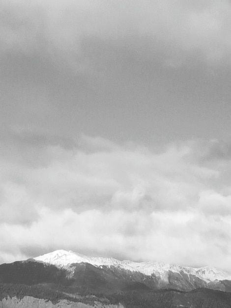 Foto la vista panoramica di una montagna coperta di neve contro un cielo nuvoloso