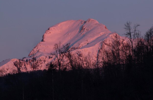 Photo scenic view of snowcapped mountain against sky at sunset