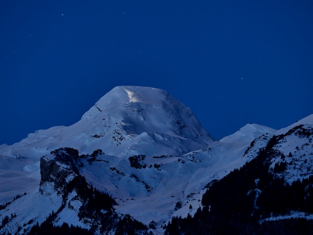 Photo scenic view of snowcapped mountains against blue sky at night