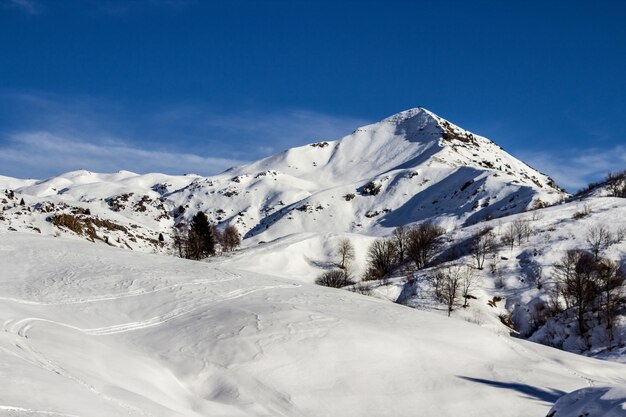 Scenic view of snowcapped mountains against blue sky