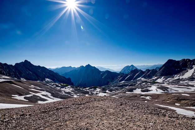 Scenic view of snowcapped mountains against blue sky