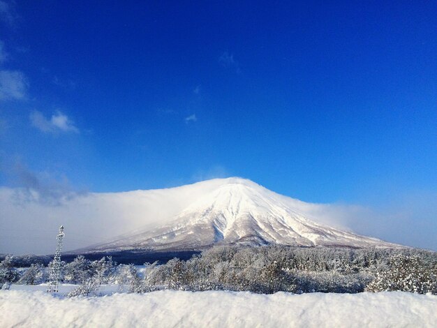 Scenic view of snowcapped mountains against blue sky