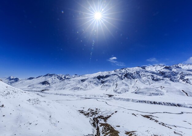 Scenic view of snowcapped mountains against blue sky